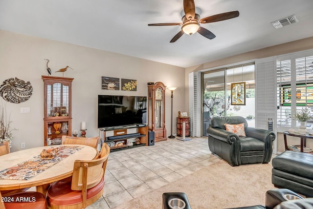 living room with ceiling fan, light tile patterned floors, and vaulted ceiling