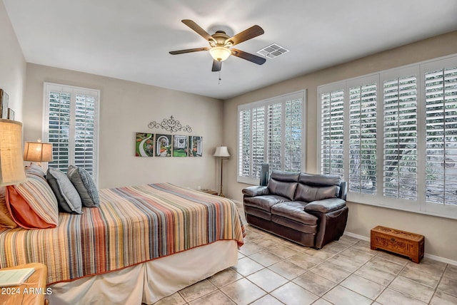 tiled bedroom featuring multiple windows and ceiling fan