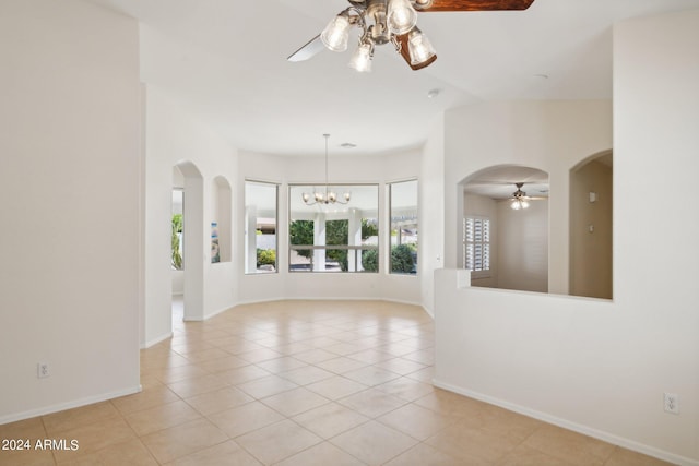 15016 W Monterey Way, Goodyear, AZ 85395 - empty room with light tile patterned floors, baseboards, ceiling fan with notable chandelier, and arched walkways