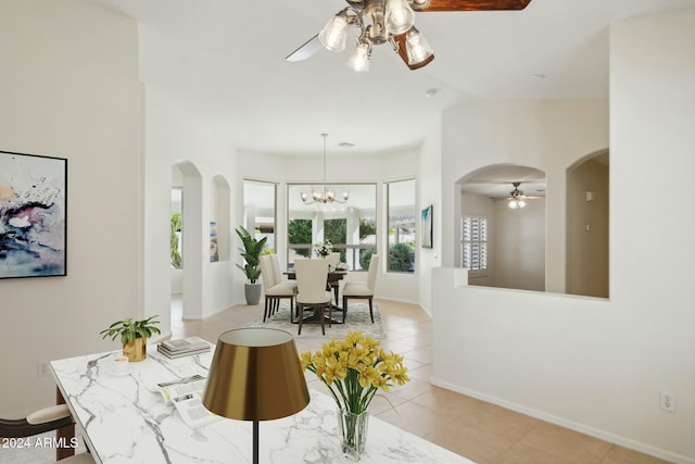 15016 W Monterey Way, Goodyear, AZ 85395 - dining area featuring arched walkways, baseboards, light tile patterned floors, and ceiling fan with notable chandelier