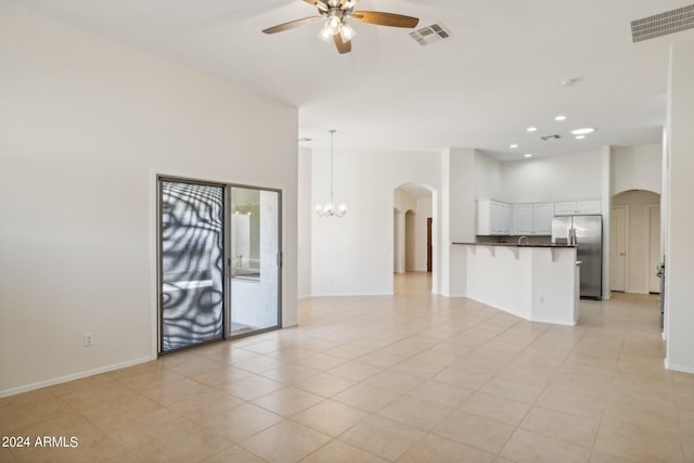 15016 W Monterey Way, Goodyear, AZ 85395 - unfurnished living room with ceiling fan with notable chandelier, arched walkways, a towering ceiling, and visible vents