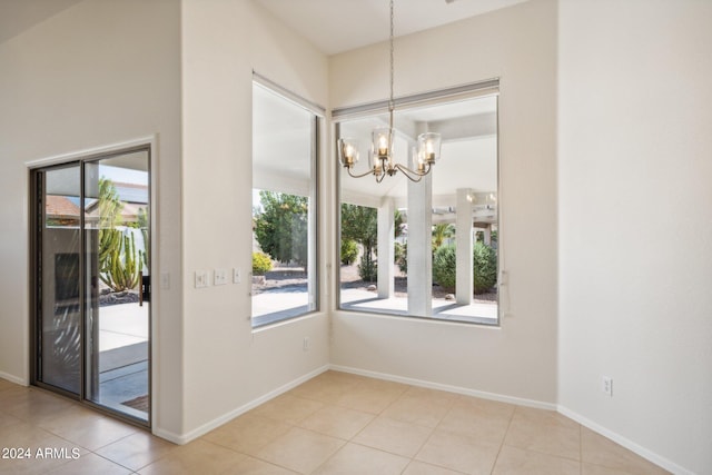 unfurnished dining area featuring tile patterned flooring and a notable chandelier