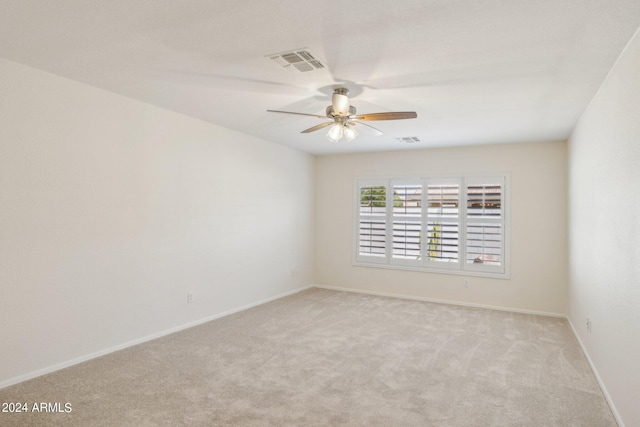 carpeted spare room featuring ceiling fan