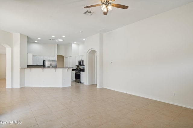 15016 W Monterey Way, Goodyear, AZ 85395 - unfurnished living room featuring visible vents, recessed lighting, arched walkways, a ceiling fan, and a high ceiling