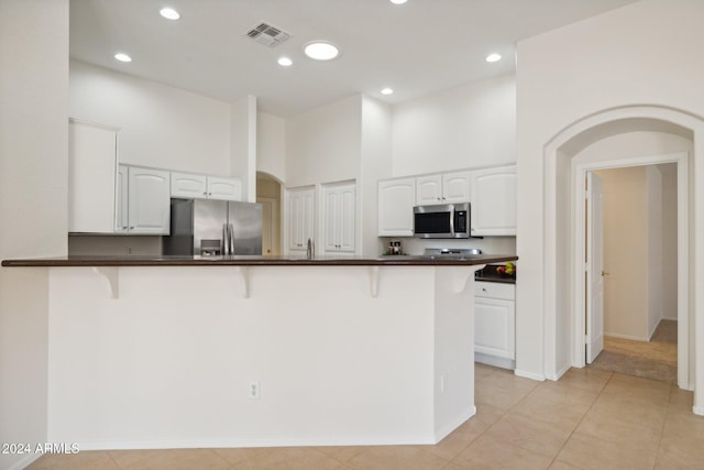 15016 W Monterey Way, Goodyear, AZ 85395 - kitchen featuring dark countertops, stainless steel appliances, visible vents, and a breakfast bar