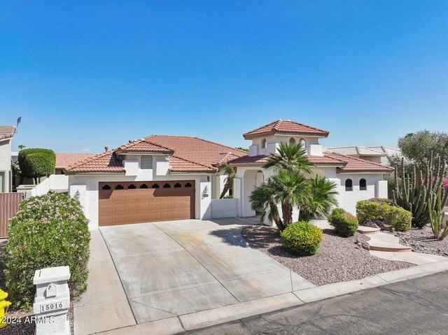 15016 W Monterey Way, Goodyear, AZ 85395 - mediterranean / spanish-style home with an attached garage, stucco siding, a tile roof, and driveway