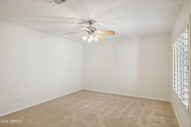 carpeted spare room with ceiling fan and plenty of natural light