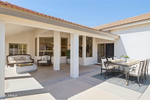 view of patio with an outdoor living space with a fire pit