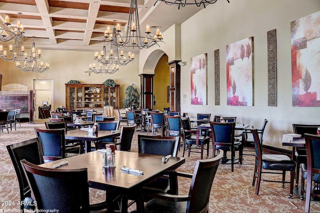 dining space featuring beam ceiling, a towering ceiling, and coffered ceiling