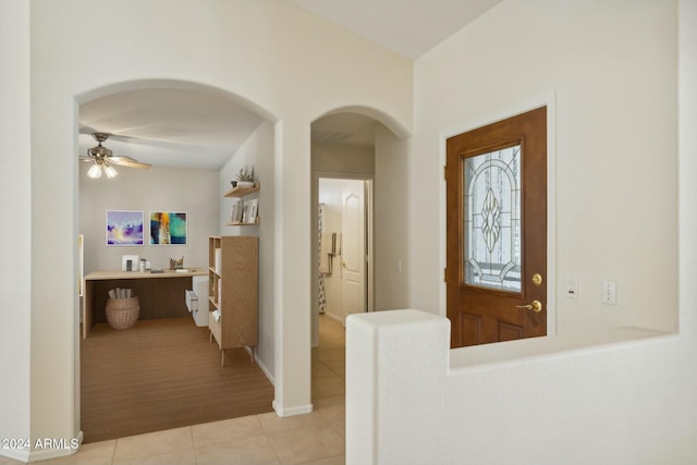 15016 W Monterey Way, Goodyear, AZ 85395 - entrance foyer with light tile patterned floors, baseboards, a ceiling fan, and arched walkways