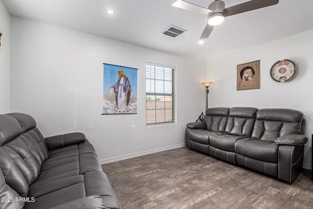 living room featuring dark wood-type flooring and ceiling fan