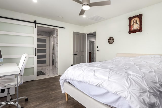 bedroom with dark hardwood / wood-style flooring, a barn door, and ceiling fan