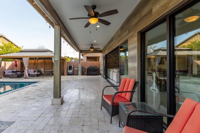 view of patio with a gazebo, ceiling fan, outdoor lounge area, and a fenced in pool