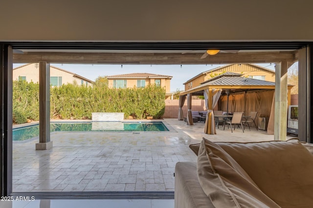 view of patio / terrace featuring a fenced in pool and a gazebo