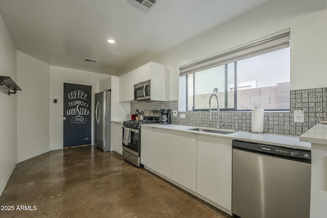kitchen featuring white cabinetry, stainless steel appliances, sink, and backsplash