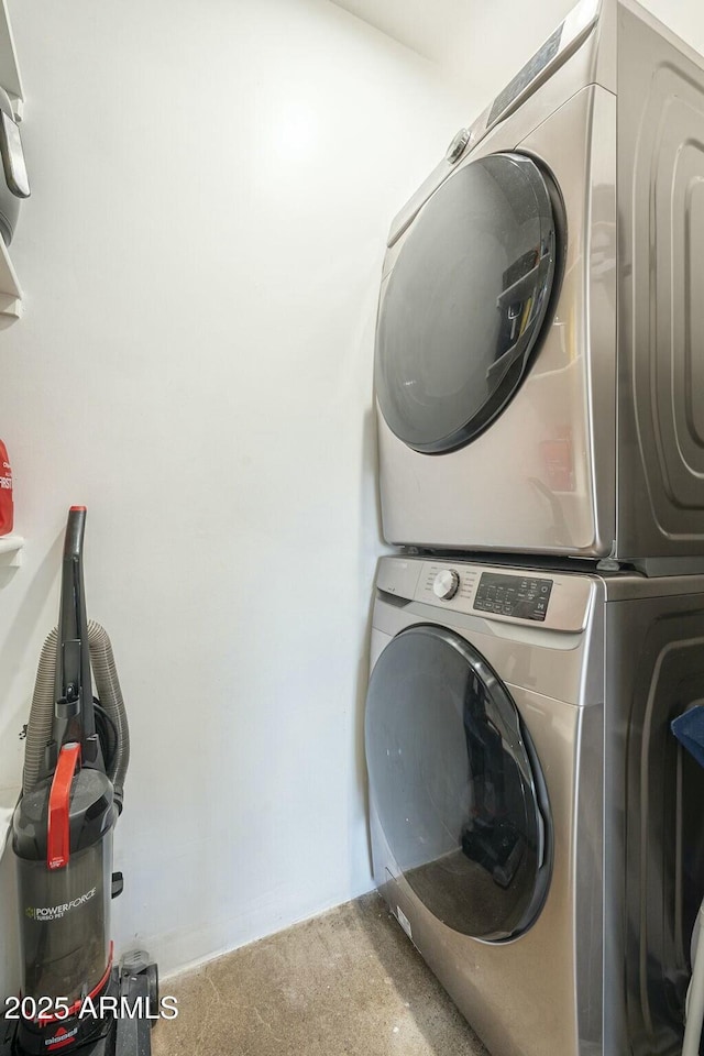 clothes washing area with stacked washer / dryer