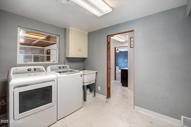 126 E Cattle Ln, Taylor, AZ 85939 - washroom featuring cabinet space, washer and clothes dryer, and light marble finish floors
