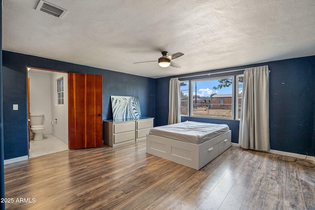 126 E Cattle Ln, Taylor, AZ 85939 - bedroom with a textured ceiling, wood finished floors, ensuite bathroom, and a ceiling fan