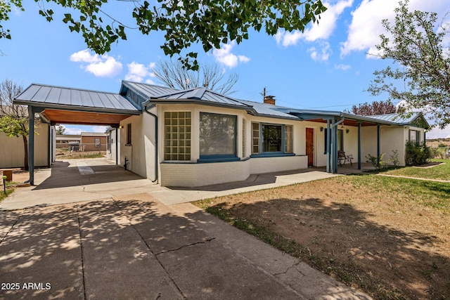 126 E Cattle Ln, Taylor, AZ 85939 - ranch-style house with a standing seam roof, concrete driveway, a metal roof, and solar panels