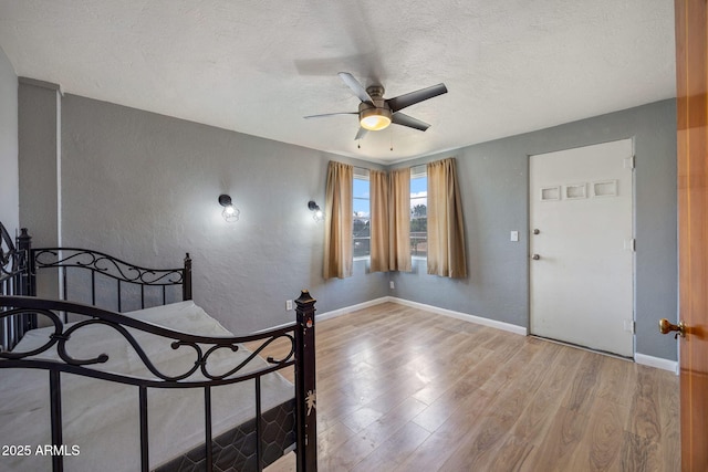 126 E Cattle Ln, Taylor, AZ 85939 - bedroom featuring wood finished floors, a textured wall, a textured ceiling, and ceiling fan