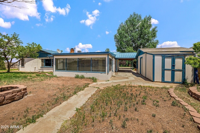 126 E Cattle Ln, Taylor, AZ 85939 - back of house featuring an outdoor fire pit, a shed, a chimney, and a metal roof