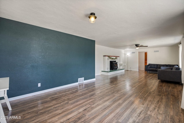 126 E Cattle Ln, Taylor, AZ 85939 - unfurnished living room featuring wood finished floors, ceiling fan, and a warm lit fireplace