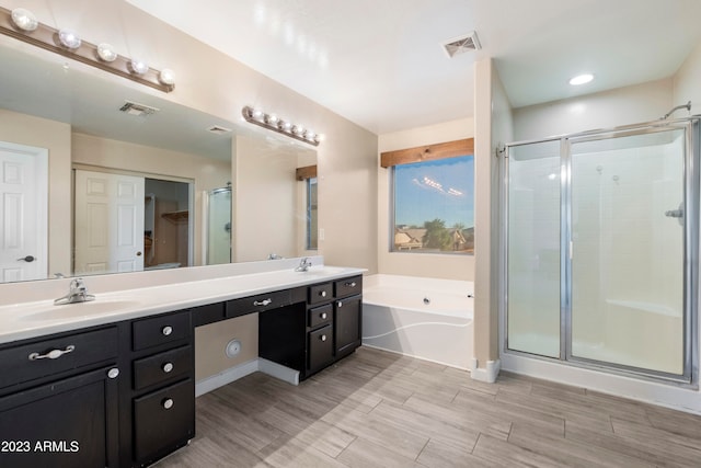 bathroom featuring shower with separate bathtub and vanity