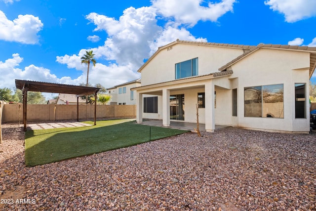 back of property with a lawn and a patio area