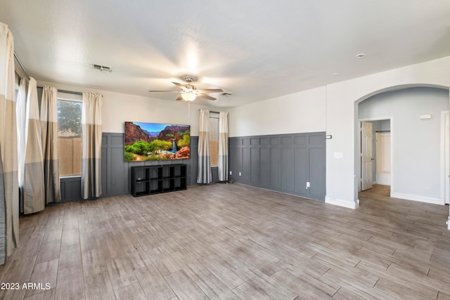 unfurnished living room featuring ceiling fan and hardwood / wood-style flooring