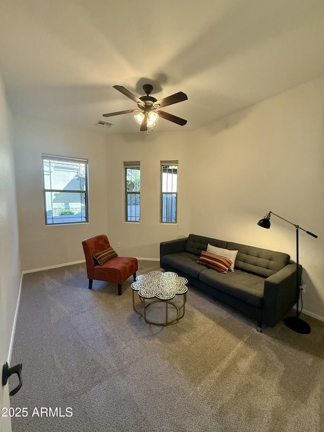 living room with a healthy amount of sunlight, baseboards, visible vents, and carpet flooring