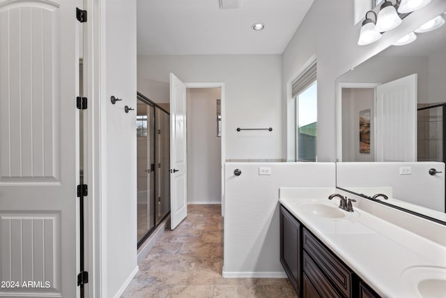 full bathroom with a stall shower, a sink, baseboards, and double vanity