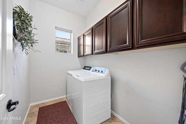 laundry room featuring cabinet space, baseboards, and washer and clothes dryer