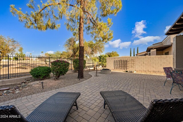 view of patio featuring an outdoor fire pit and fence