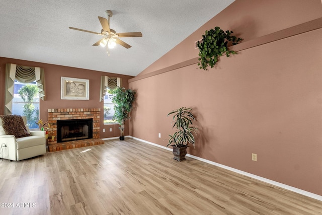 unfurnished living room with a textured ceiling, ceiling fan, light wood-type flooring, and vaulted ceiling