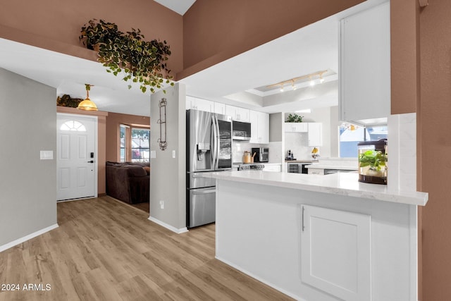 kitchen with kitchen peninsula, white cabinetry, light hardwood / wood-style floors, stainless steel appliances, and track lighting