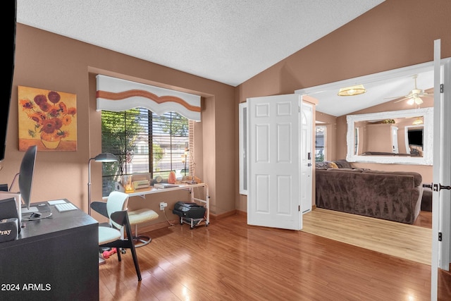 office area with lofted ceiling, hardwood / wood-style floors, a textured ceiling, and ceiling fan