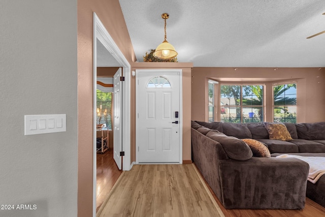 entrance foyer with ceiling fan, a textured ceiling, light hardwood / wood-style floors, and plenty of natural light