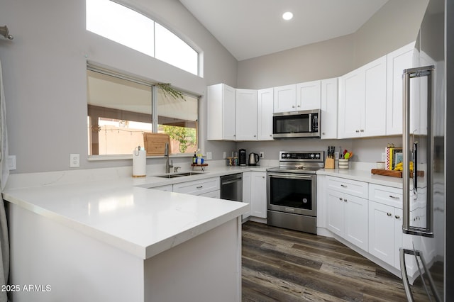 kitchen featuring kitchen peninsula, white cabinetry, sink, and appliances with stainless steel finishes