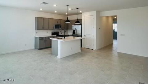 25137 W Wayland Dr, Buckeye, AZ 85326 - kitchen with appliances with stainless steel finishes, gray cabinetry, light countertops, an island with sink, and decorative light fixtures