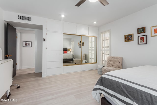 bedroom with a closet, light wood-type flooring, and ceiling fan