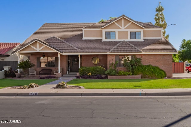 view of front of property featuring brick siding, a porch, a tile roof, and ceiling fan
