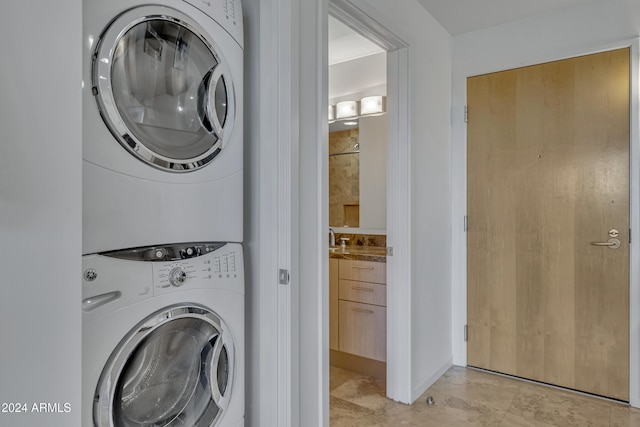 washroom featuring stacked washer / drying machine and light tile patterned floors