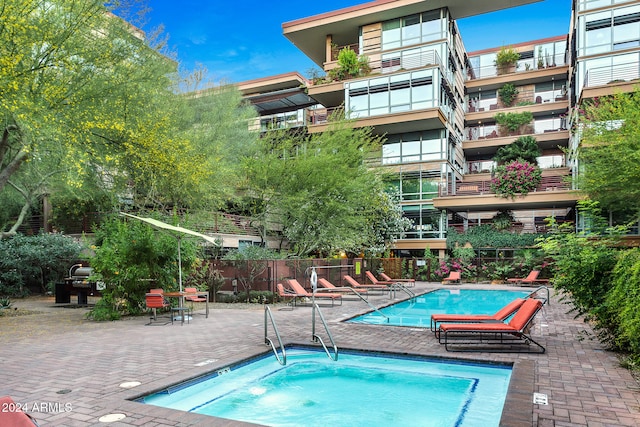 view of swimming pool with a patio and a community hot tub