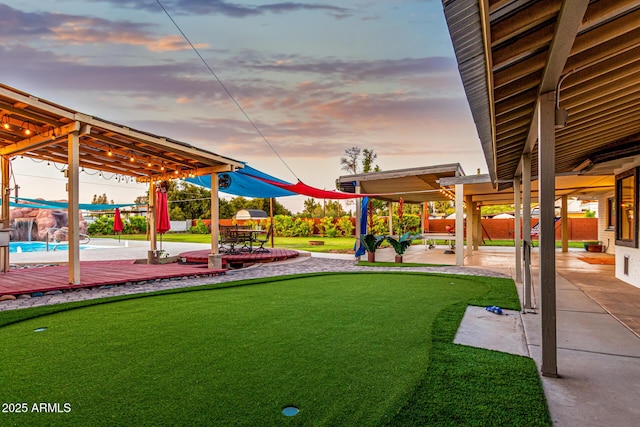 yard at dusk featuring a patio