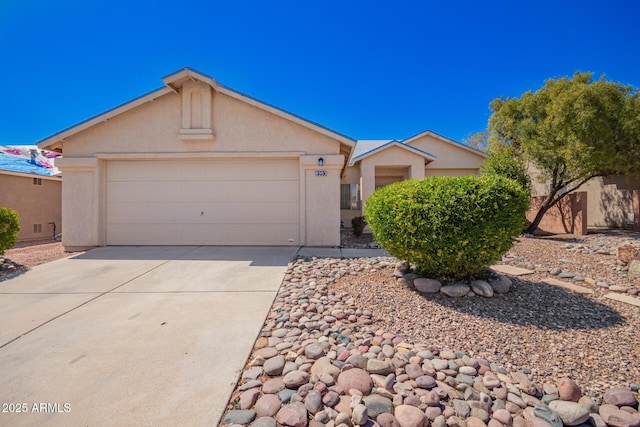 ranch-style house with a garage, driveway, and stucco siding
