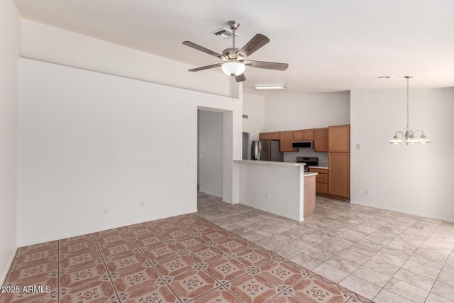 unfurnished living room with ceiling fan with notable chandelier, vaulted ceiling, visible vents, and baseboards