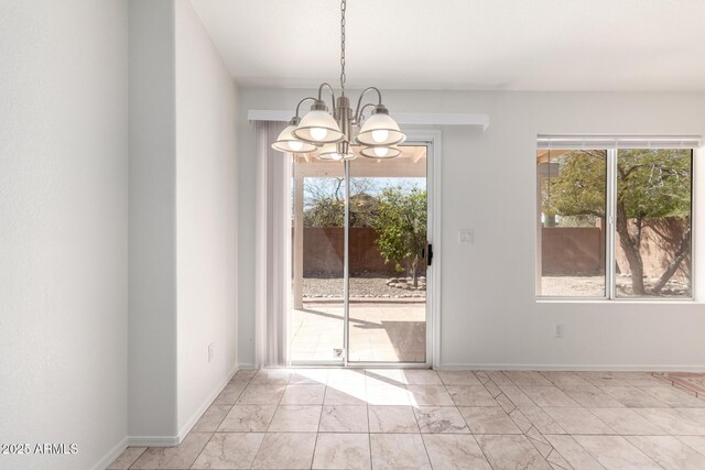 unfurnished dining area featuring baseboards, marble finish floor, and a notable chandelier