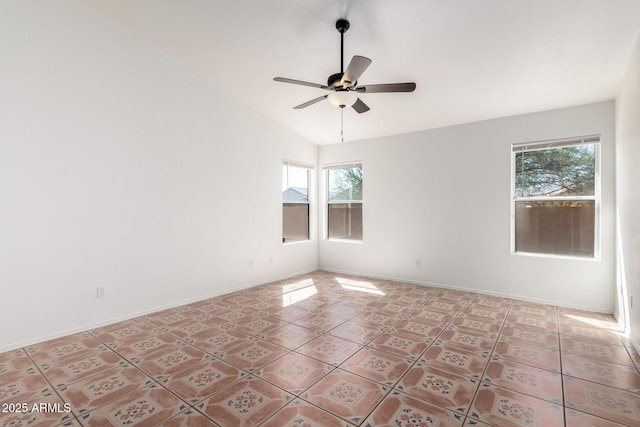 empty room with baseboards, ceiling fan, vaulted ceiling, and light tile patterned flooring