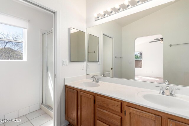 full bath with toilet, a sink, tile patterned floors, and a shower stall