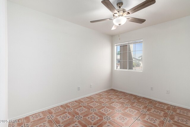 spare room featuring baseboards and a ceiling fan